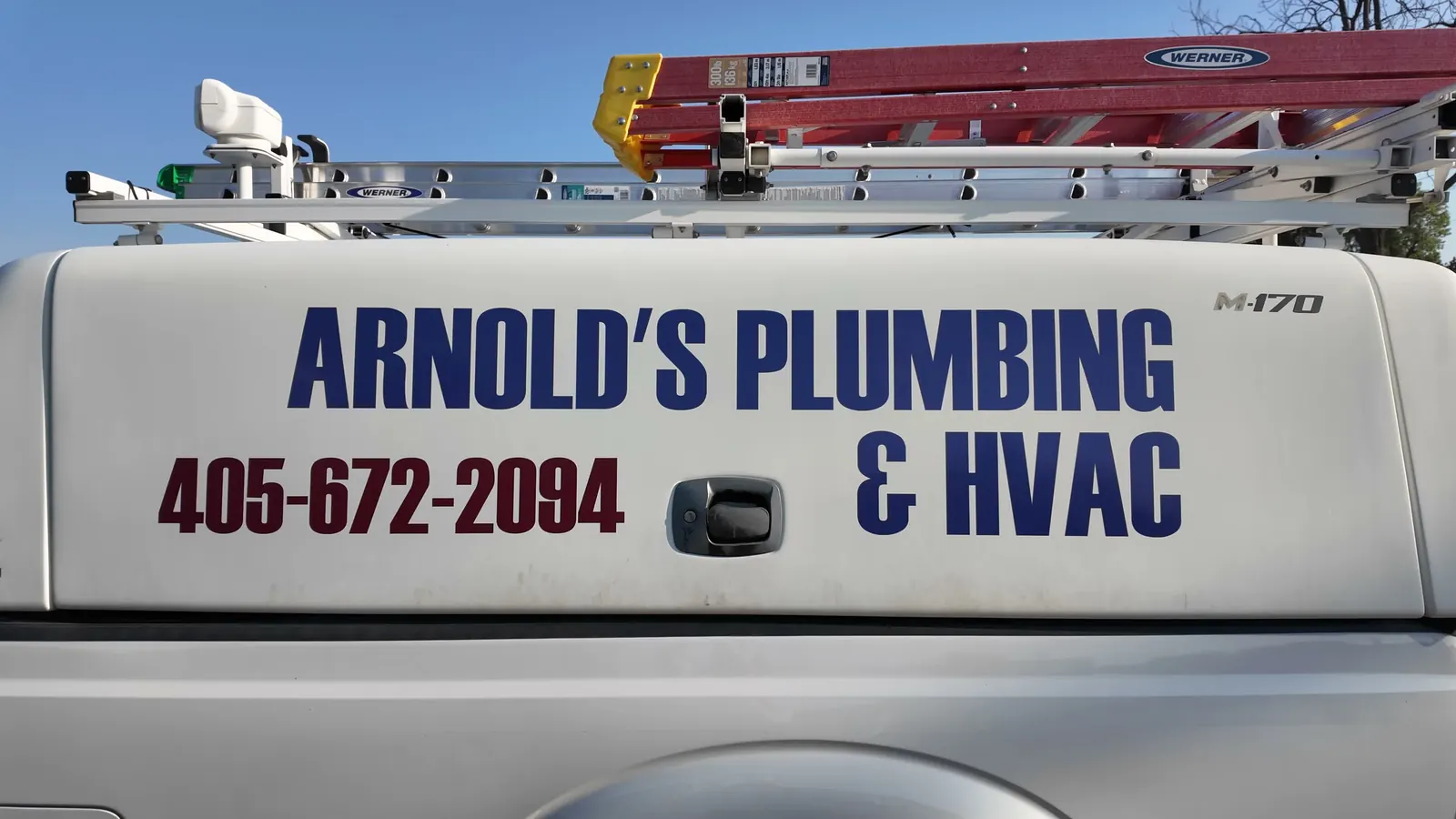 Arnold's Plumbing, Heating & Air lettering and phone number on a company service vehicle