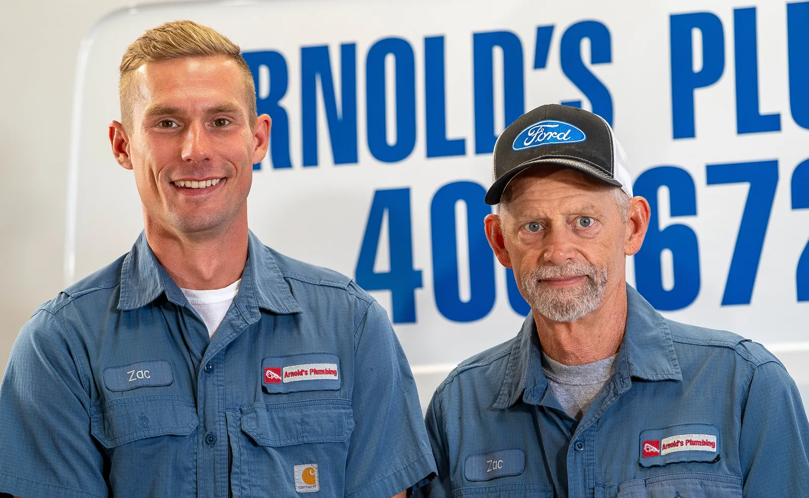 Two Arnold's team members in front of a company van