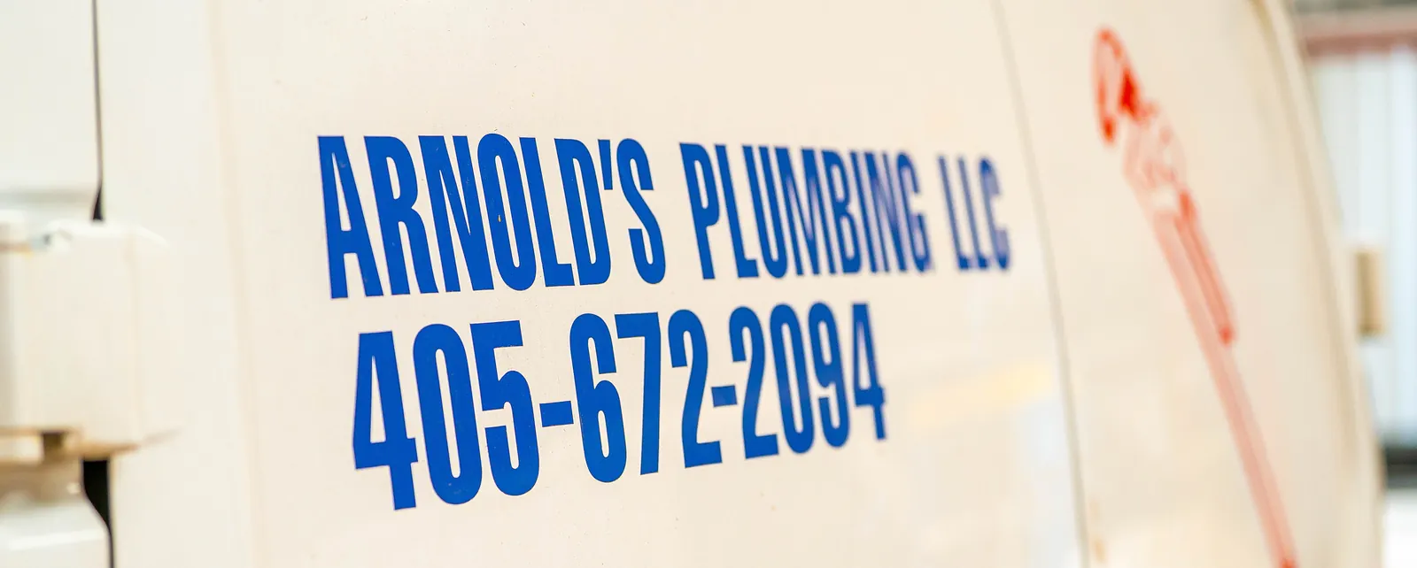 Company name and phone number on an Arnold's service van