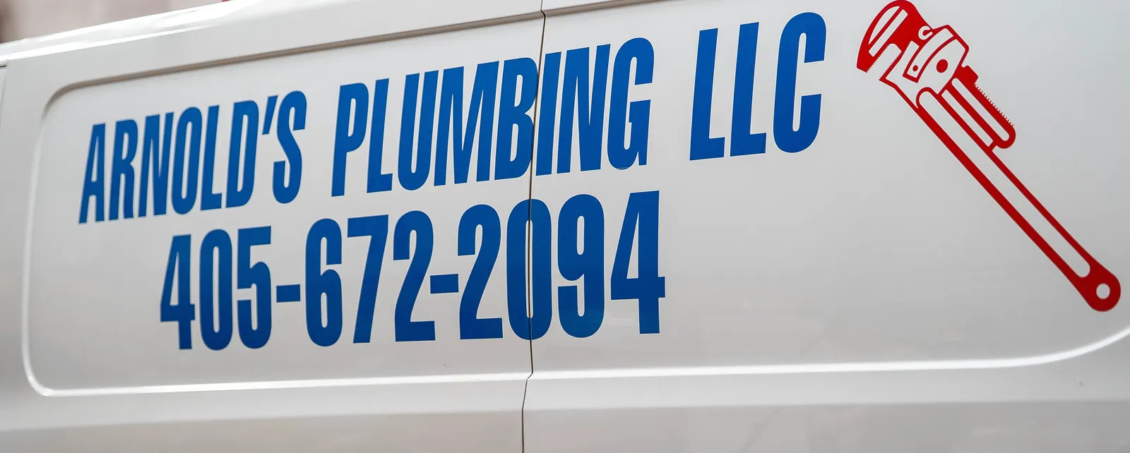 Arnold's Plumbing, Heating & Air name and phone number on the side of a service van