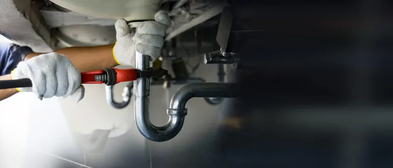 Plumbing work beneath a sink